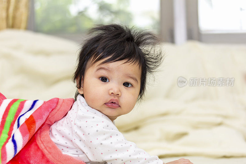 portrait asian cute baby in a blanket crawl or wake up on the bed in room